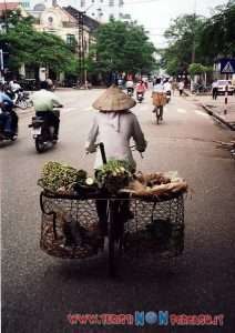 Strada del centro storico di Hanoi con negozi e motorini