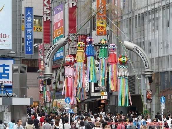 Incrocio di Shibuya a Tokyo con folla e luci notturne