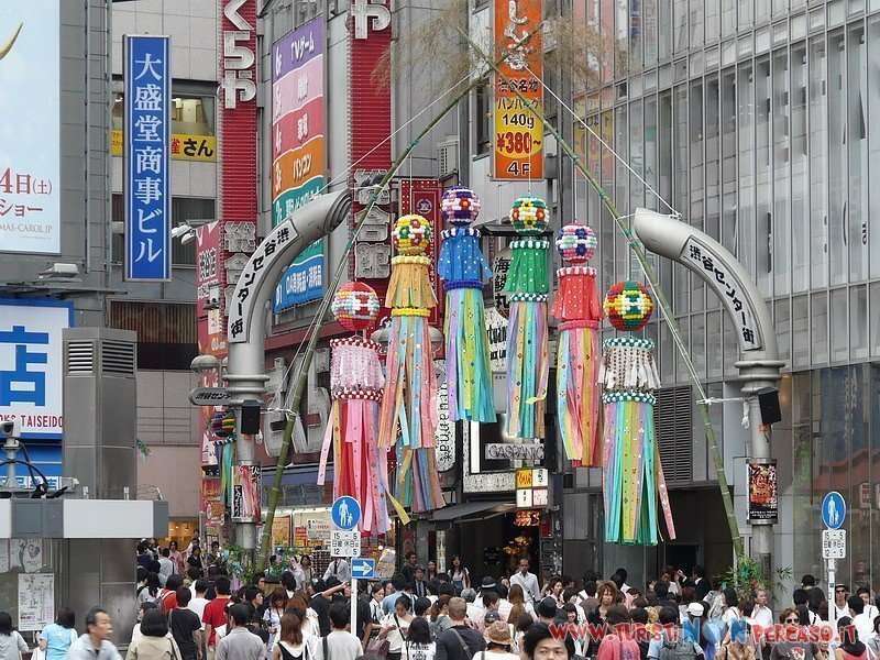 Incrocio di Shibuya a Tokyo con folla e luci notturne